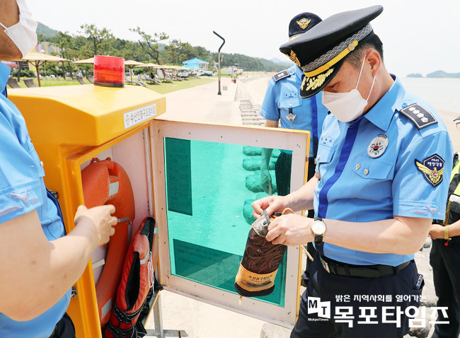 임재수 목포해양경찰서장이 해수욕장에 비치된 수난인명구조장비함에서 안전장비들을 살펴보고 있다.